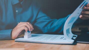 Businessman validates and manages business documents and agreements, signing a business contract approval of contract documents confirmation or warranty certificate,approval stamp photo