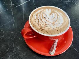 cup of cappuccino coffee on black table photo