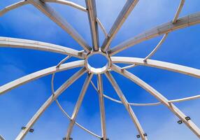 Metal construction of art object on background of blue sky background. Amphitheater in Navruz Park in Tashkent in Uzbekistan photo