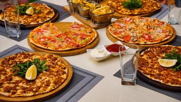 Variety of Pizzas on Table With Drinks and Fries photo