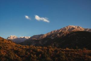 landscape with mountain peaks background sky with clouds at sunset in autumn photo