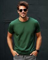 A man in sunglasses poses for a photo while wearing a blank green t-shirt