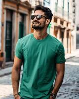 A man wearing a green t-shirt smiles while walking in a city photo