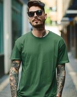 A stylishly dressed man poses with a blank green t-shirt in an urban setting photo