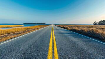 Empty road leading to the sea with a blue sky photo