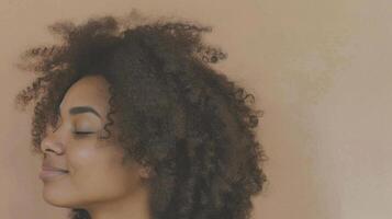 A woman with curly hair, eyes closed, seemingly lost in thought photo