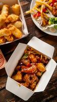 Chinese food takeout, including spring rolls and sweet and sour chicken photo