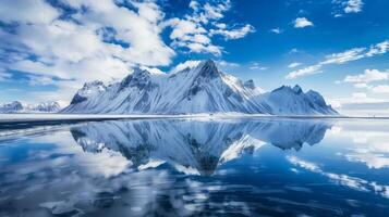 A picturesque scene of snow-capped mountains reflecting in a calm lake in Iceland photo