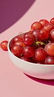 A close-up image of a bowl filled with red grapes photo