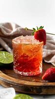 Close-up of a red cocktail in a cut glass with a strawberry garnish photo