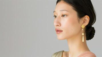 A woman with dark hair and flawless skin wears golden earrings photo
