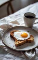 A heart-shaped fried egg sits atop a slice of toast photo