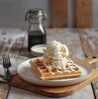 A plate of waffles topped with vanilla ice cream, dusted with powdered sugar photo
