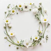 White flowers arranged in a circular frame on a white surface photo