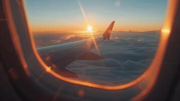 Sunset view from plane window, with wing and clouds photo