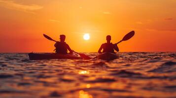 Two kayakers paddle towards the setting sun photo