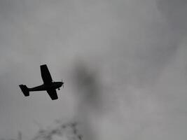 a small airplane flying through a cloudy sky photo