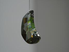 a transparent moon crystal ornament hanging from a string photo