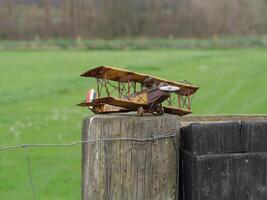 a small model airplane sitting on a fence post photo