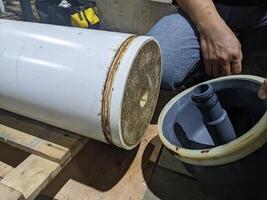 Inspection Water Ultra Filtration Membrane skid Maintenance. A close-up view of a water filter cylinder, featuring a white outer layer and a gray inner tube. photo