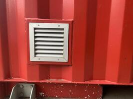 Close-up of a air vent ducting on a red shipping container photo