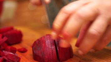 woman cutting up a pile of carrots on a cutting board. The carrots are sliced into thin strips and are piled on top of each other. Concept of preparation for a meal. video