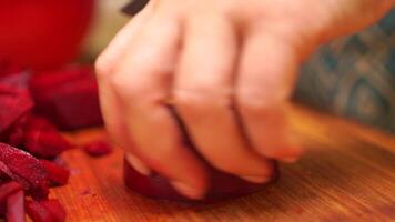 woman cutting up a pile of carrots on a cutting board. The carrots are sliced into thin strips and are piled on top of each other. Concept of preparation for a meal. video