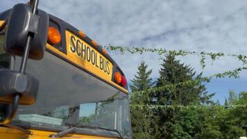 Shot of retro-styled yellow school bus with extended red stop sign standing still on serene road, empty vehicle with no driver awaiting children to boarding, transportation concept, copy space video