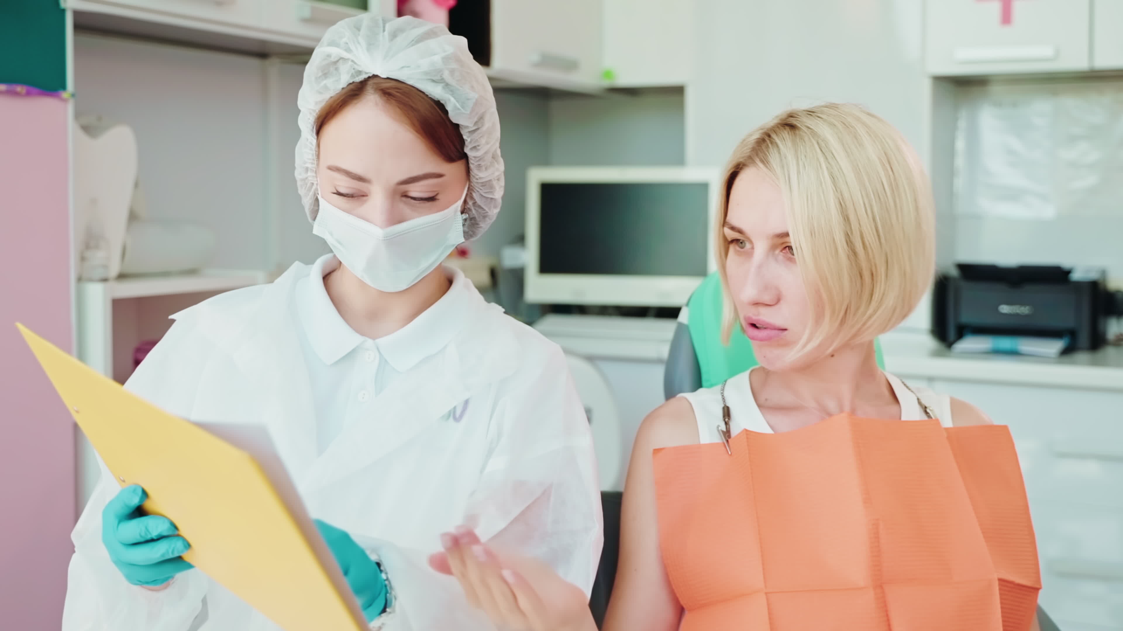 woman patient at dentist appointment, giving questions to female doctor
