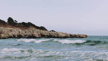 A peaceful scene of waves rolling in on the shore on a cloudy day video