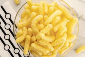 Corn sticks in bowl on table still life. Top view photo