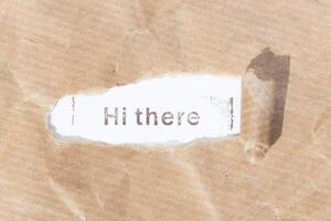 Hi There message. Brown paper torn stripe with text on white paper background photo