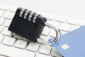 Security lock closed on credit card on computer keyboard . Financial data protection concept photo