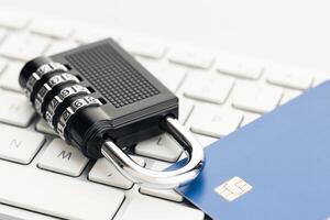 Padlock and credit card on computer keyboard. E-commerce internet and finance security concept photo