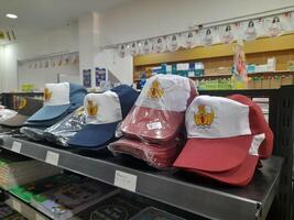 Lombok Island, Indonesia - July 6, 2024 - A colorful display of school caps placed on a shelf at a stationery store for public schools in Indonesia. photo
