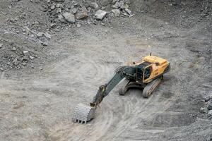 Mining in the granite quarry. Working mining machine - digger. Mining industry. photo