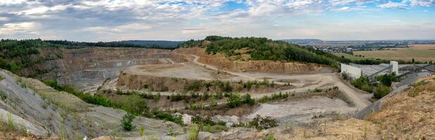 Panorama of opencast mining quarry with machinery. Quarrying of stones for construction works. Mining industry in quarry. photo