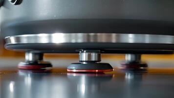 Macro shot of the underside of a portable induction cooker revealing the sy metal frame and rubber feet for stability and durability while cooking video