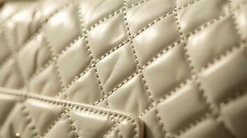 A detailed shot of the quilted pattern on a white leather handbag showing the depth and texture of the design video