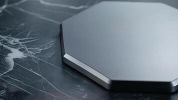 An overhead shot of a wireless charging pad in the shape of a hexagon. The pad has a metallic silver finish and a slim profile for easy portability video