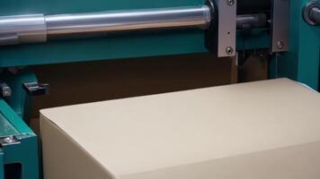 A closeup of a machine neatly folding and tucking cardboard to create a perfectly sealed box.. video