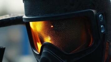 A closeup of the welding mask with the reflection of the fiery welding process visible in the lens.. video