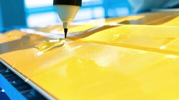 A closeup of a shiny yellow substance being carefully spread onto the surface of a solar panel completing the first layer of the antireflective coating.. video