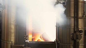 The steam and heat from a fully functioning biomass boiler can be seen up close demonstrating the factorys use of renewable energy sources.. video
