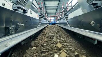 A conveyor belt carrying chunks of ore to be sorted and refined in a series of industrial machines.. video
