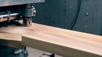 A closeup of a board of wood being pressed and shaped by a large hydraulic machine into the form of a bookshelf.. video
