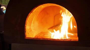 The warm glow of a woodfired kiln highlights the vibrant colors and intricate patterns of handcrafted ceramic tiles.. video