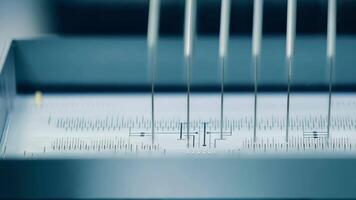 A machine threading fine wires through the internals of a medical device ready for final assembly.. video