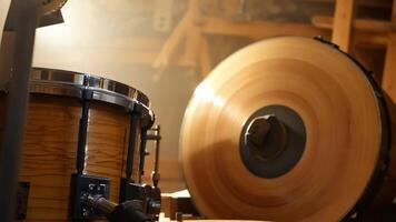 The gentle hum of a woodworking machine can be heard as a section of a drum shell is expertly carved out.. video