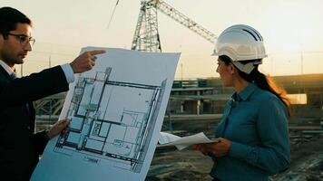 Architects and engineers discussing blueprints at a construction site video